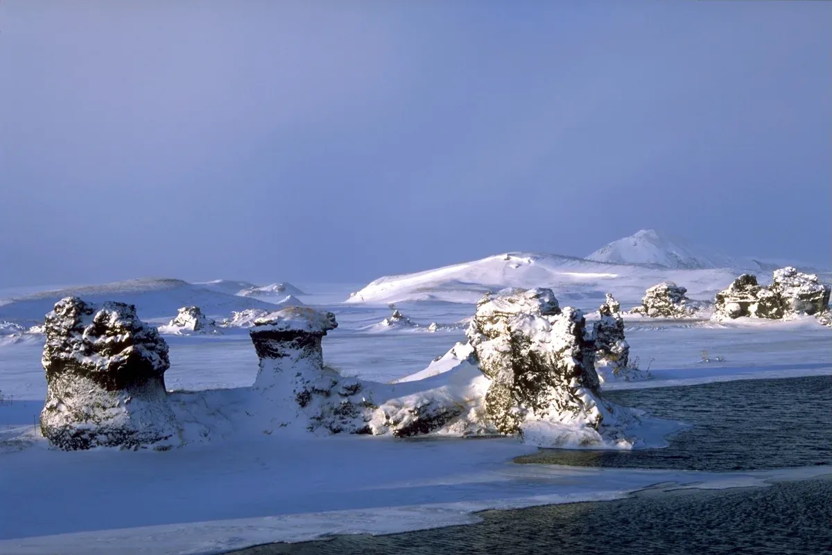 Snow-covered lava pillars and frozen shoreline at Mývatn in winter, North Iceland, where the ice fishing season runs on nearby lakes